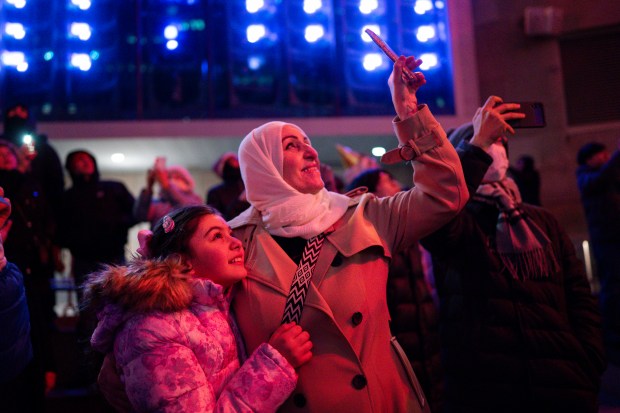 People watch fireworks along the Chicago River in the early morning hours of New Year's Day Jan. 1, 2025 in Chicago, Ill. (Vincent Alban/for The Chicago Tribune)