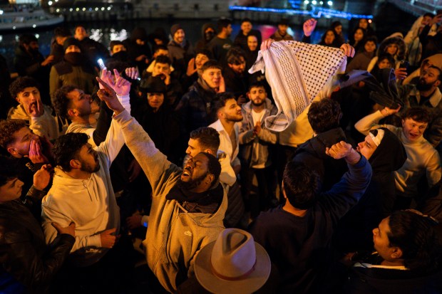 People cheer for the new year along the Chicago River in the early morning hours of New Year's Day Jan. 1, 2025 in Chicago, Ill. (Vincent Alban/for The Chicago Tribune)