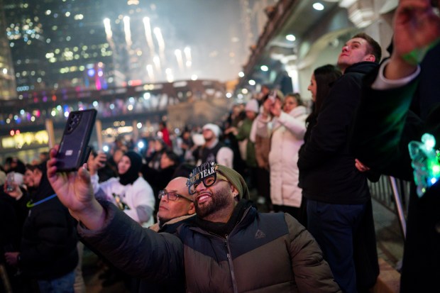 People watch fireworks along the Chicago River in the early morning hours of New Year's Day Jan. 1, 2025 in Chicago. (Vincent Alban/for The Chicago Tribune)