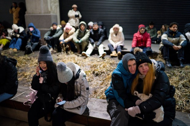 Zach and Kathi wait for the fireworks display along the Chicago River on New Year's Eve Dec. 31, 2024 in Chicago. (Vincent Alban/for The Chicago Tribune)