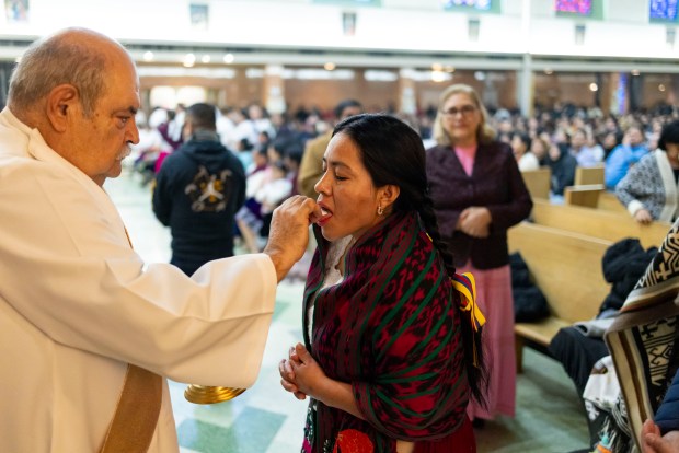 Parishioners receive communion during a Mass in honor of Nuestra Señora Virgen de la Nube, Our Lady of the Cloud, Jan. 1, 2025, at Our Lady of Mercy . (Brian Cassella/Chicago Tribune)