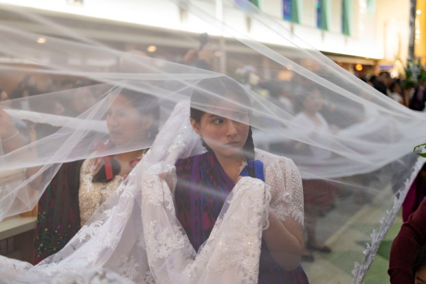 Parishioners carry a train behind a figure out of the church after a Mass in honor of Nuestra Señora Virgen de la Nube, Our Lady of the Cloud, on New Year's Day, Jan. 1, 2025, at Our Lady of Mercy. (Brian Cassella/Chicago Tribune)