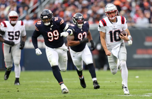 Bears defensive tackle Gervon Dexter Sr. (99) can't catch up as Patriots quarterback Drake Maye scrambles for a first down. (Chris Sweda/Chicago Tribune)