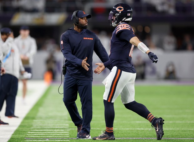 Bears interim coach Thomas Brown congratulates quarterback Caleb Williams after a touchdown pass against the Vikings on Dec. 16, 2024, in Minneapolis. (Chris Sweda/Chicago Tribune)