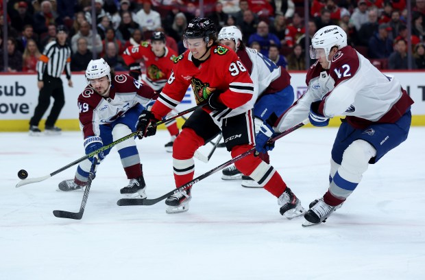 Chicago Blackhawks center Connor Bedard (98) battles with Colorado Avalanche defensemen Samuel Girard (left) and Josh Manson (right) in the first period of a game at the United Center in Chicago on Jan. 8, 2025. (Chris Sweda/Chicago Tribune)