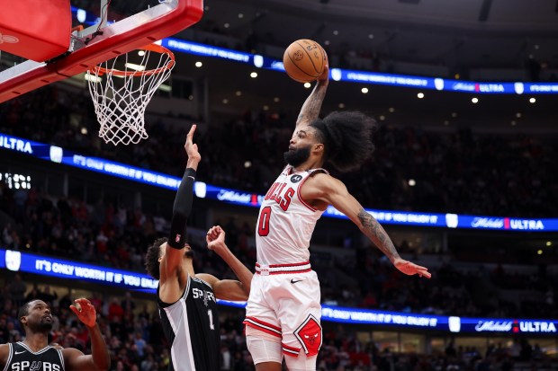 Chicago Bulls guard Coby White dunks the ball past San Antonio Spurs center Victor Wembanyama to give the Bulls a 113-110 lead in the final minute of the fourth period at the United Center on Monday, Jan. 6, 2025. (Armando L. Sanchez/Chicago Tribune)