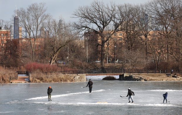 A small group plays hockey on the frozen lagoon in Chicago's Humboldt Park on Jan. 20, 2025. (Chris Sweda/Chicago Tribune)