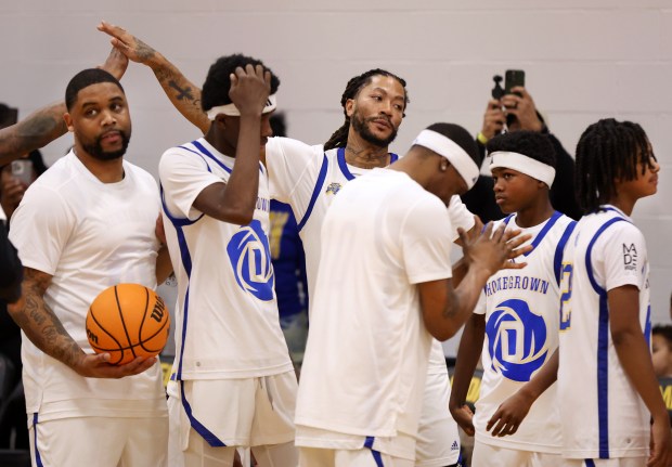 Derrick Rose high-fives teammates before playing in a game with youths at Simeon Career Academy in Chicago on Friday, Jan. 3, 2025. The Simeon graduate and former Chicago Bulls superstar is being honored at the United Center on Saturday night during a Bulls vs. New York Knicks game. (Chris Sweda/Chicago Tribune)