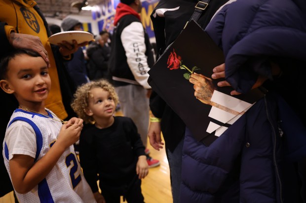 A person holds an Adidas sponsored image of Derrick Rose holding a rose as fans of the former Simeon Career Academy and Chicago Bulls player gather on court at Simeon in Chicago following a game featuring Rose on Friday, Jan. 3, 2025. (Chris Sweda/Chicago Tribune)