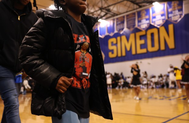 A young fan of Derrick Rose walks across the basketball court at Simeon Career Academy in Chicago while wearing a shirt featuring Rose posing with his NBA MVP trophy as Rose was honored at Simeon on Friday, Jan. 3, 2025. Rose, the Simeon graduate and former Chicago Bulls superstar, is being honored at the United Center on Saturday night during a Bulls vs. New York Knicks game. (Chris Sweda/Chicago Tribune)