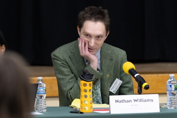 Downers Grove library board member Nathan Williams speaks during a joint meeting of the Village Council and the library board of trustees at Herrick Middle School in Downers Grove on Jan. 2, 2025. (Troy Stolt/for the Chicago Tribune)