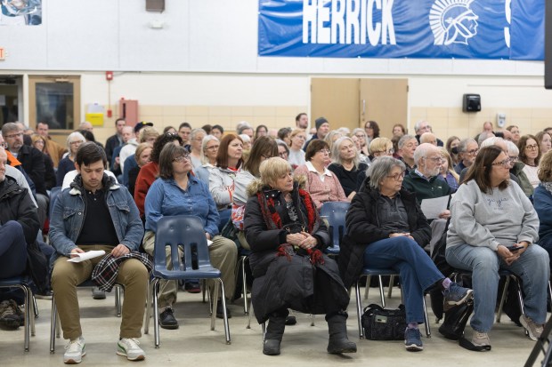 Residents of Downers Grove attend a joint meeting of the Village Council and the library board of trustees at Herrick Middle School in Downers Grove on Jan. 2, 2025. (Troy Stolt/for the Chicago Tribune)