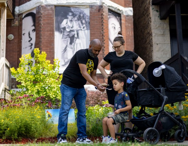 Tshey and Lisa Gebre feed their son Samson, 4, during an 82nd birthday ice cream social for Emmett Till on July 23, 2023, at the Till-Mobley House in the West Woodlawn neighborhood of Chicago. (Brian Cassella/Chicago Tribune)