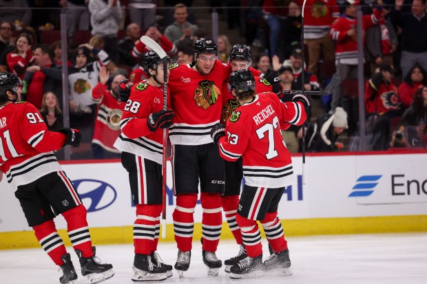 Chicago Blackhawks center Colton Dach (28), Chicago Blackhawks defenseman Louis Crevier (46), Chicago Blackhawks defenseman Alex Vlasic (72), and Chicago Blackhawks left wing Lukas Reichel (73) celebrate with Crevier after he scored during the first period against the Calgary Flames at the United Center Monday Jan. 13, 2025, in Chicago. (Armando L. Sanchez/Chicago Tribune)