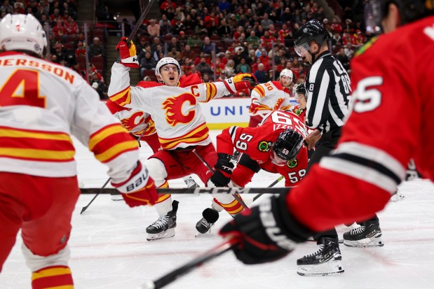 Calgary Flames center Mikael Backlund (11) falls on the ice while facing off with Chicago Blackhawks left wing Tyler Bertuzzi (59) during the first period at the United Center Monday Jan. 13, 2025, in Chicago. (Armando L. Sanchez/Chicago Tribune)