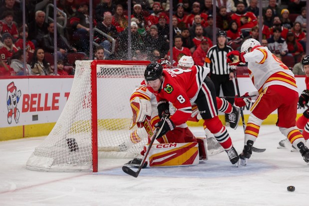 Chicago Blackhawks center Ryan Donato (8) falls over Calgary Flames goaltender Dustin Wolf (32) and would be called for interference during the first period at the United Center Monday Jan. 13, 2025, in Chicago. (Armando L. Sanchez/Chicago Tribune)