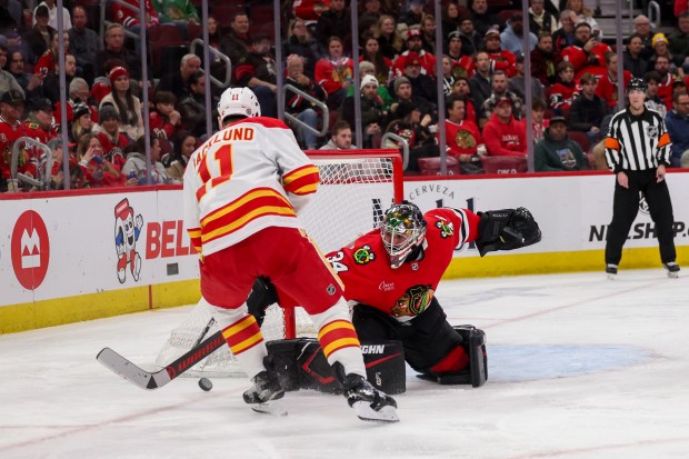 Chicago Blackhawks goaltender Petr Mrazek (34) blocks a shot from Calgary Flames center Mikael Backlund (11) during the second period at the United Center Monday Jan. 13, 2025, in Chicago. (Armando L. Sanchez/Chicago Tribune)