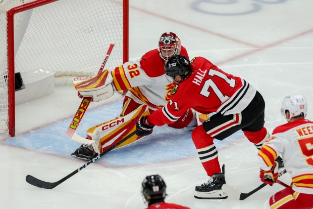 Calgary Flames goaltender Dustin Wolf (32) blocks a shot from Chicago Blackhawks left wing Taylor Hall (71) during the third period at the United Center Monday Jan. 13, 2025, in Chicago. (Armando L. Sanchez/Chicago Tribune)