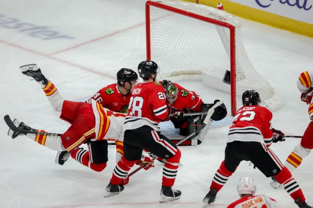 Calgary Flames center Kevin Rooney (21) falls on the ice near Chicago Blackhawks defenseman Louis Crevier (46) during the third period at the United Center Monday Jan. 13, 2025, in Chicago. (Armando L. Sanchez/Chicago Tribune)