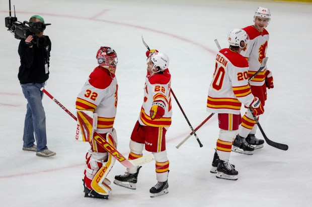 Calgary Flames goaltender Dustin Wolf (32) and Calgary Flames left wing Jakob Pelletier (22) hug after the Flames defeated the Chicago Blackhawks, 5-2, at the United Center Monday Jan. 13, 2025, in Chicago. (Armando L. Sanchez/Chicago Tribune)