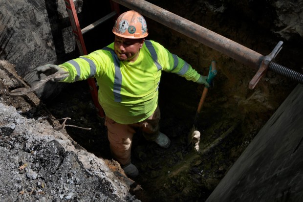 A worker prepares to remove an old lead pipe and install new copper pipe for a homeowner on south Green Street on May 2, 2024. In 2021, Illinois mandated the removal of all lead service lines with the Lead Service Line Replacement and Notification Act. (Antonio Perez/Chicago Tribune)