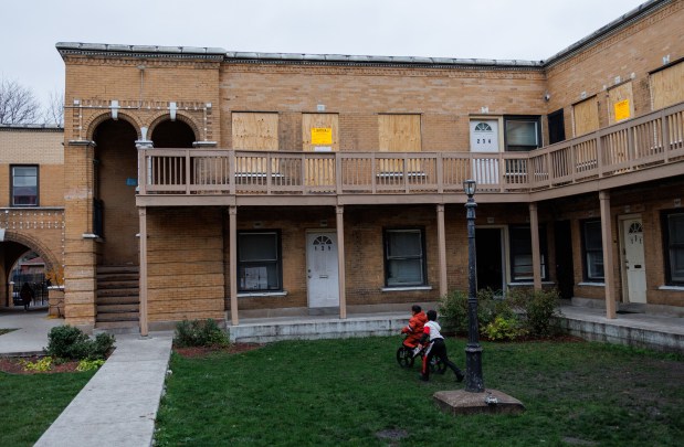 Children play in a courtyard as apartment units sit boarded up after several shootings took place earlier in the month in a residential building in Chicago's Washington Park neighborhood on Nov. 25, 2024. (Armando L. Sanchez/Chicago Tribune)