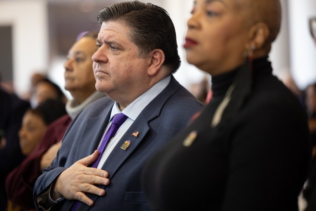 Gov. JB Pritzker places his hand on his heart during the playing of the national anthem at Rainbow PUSH Coalition's annual Dr. King Breakfast celebrating the legacy of Dr. Martin Luther King Jr. at the United Club in Soldier Field in Chicago on Jan. 20, 2025. (Audrey Richardson/Chicago Tribune)