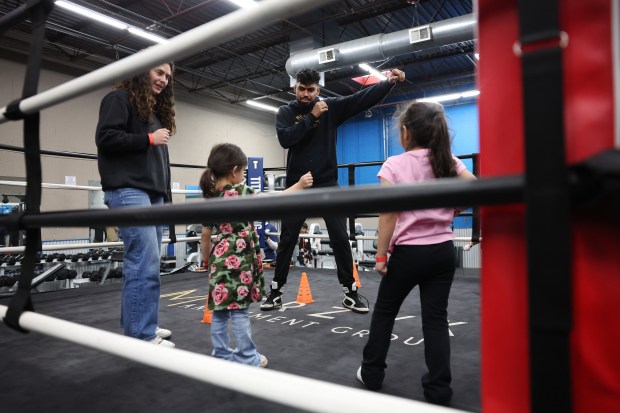 Zain Hussain teaches some boxing skills to Salma Alsikafi and sisters Zuliakha Guzeldere and Aqsa Guzeldere during a Muhammad Ali Day event in Northbrook, Jan. 17, 2025. (Chris Sweda/Chicago Tribune)