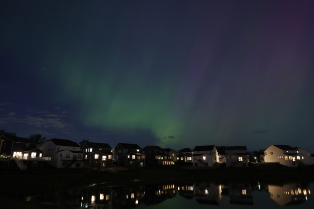 The Northern Lights briefly appear over a housing subdivision on May 10, 2024, in Kildeer. Mackinaw City, Michigan, and Bayfield, Wisconsin, are "trending destinations" for aurora borealis viewing in the Midwest. (John J. Kim/Chicago Tribune)