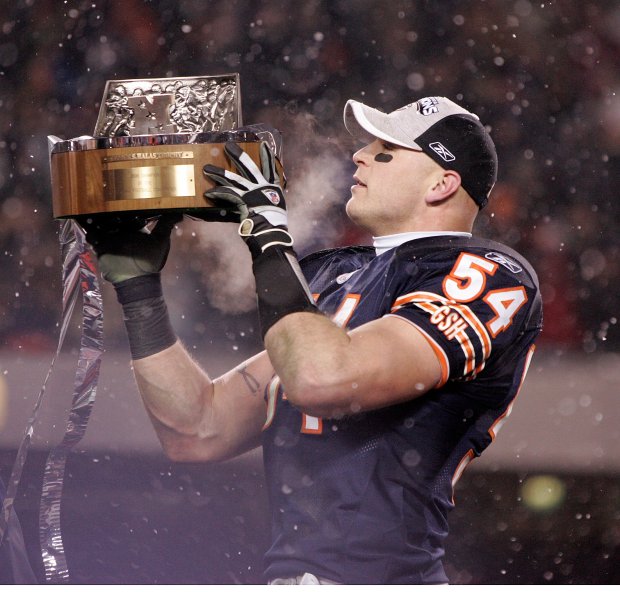 With snow falling at Soldier Field, Urlacher lifts the NFC championship trophy above his head following the Bears' 39-14 whipping of the Saints. Urlacher had a career-high four pass deflections in the game, interfering with Drew Brees' intermediate passing game and leading the club to the Super Bowl for the first time since 1985. (Jim Prisching/Chicago Tribune)