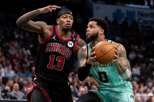 Charlotte Hornets forward Miles Bridges (0) drives to the basket while guarded by Chicago Bulls forward Torrey Craig (13) during the second half of an NBA basketball game in Charlotte, N.C., Monday, Dec. 30, 2024. (AP Photo/Jacob Kupferman)