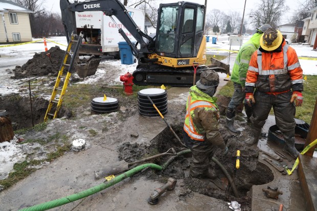 Workers tend to a water line break Jan. 24, 2024, at a house in the 14100 block of Winchester Avenue in Dixmoor.