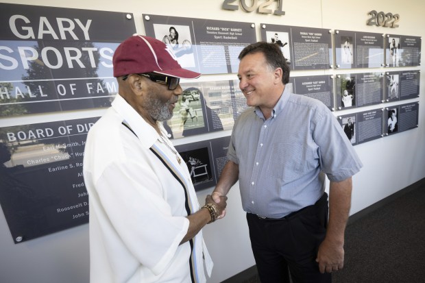 Gary Sports Hall of Fame Committee Chairman Earl Smith, on left, shakes hands with board member John Stroia in front of the newly-unveiled "Wall of Fame" at the Indiana University Northwest Arts and Sciences building on Wednesday, June 29, 2022. (Kyle Telechan for the Post-Tribune)