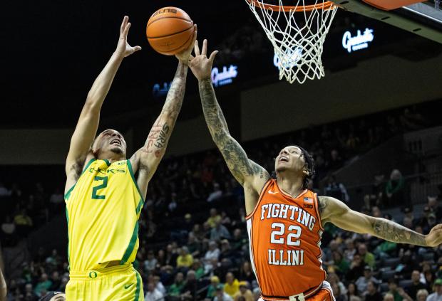 Oregon guard Jadrian Tracey (2) and Illinois guard Tre White (22) go for a rebound during the first half of an NCAA college basketball game in Eugene, Ore., Thursday, Jan. 2, 2025. (AP Photo/Thomas Boyd)