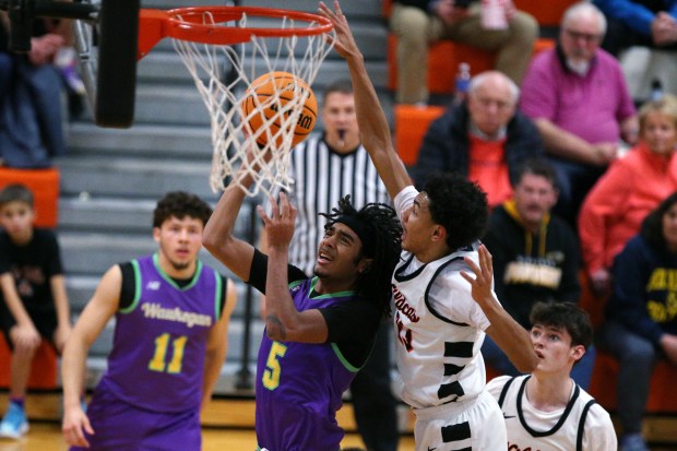 Waukegan's Antonio Xavi Granville (5), laying one up after getting around Libertyville's Terrence Davis (right), during the game on Tuesday, Jan. 7, 2024. (Mark Ukena/for the Lake County News-Sun)