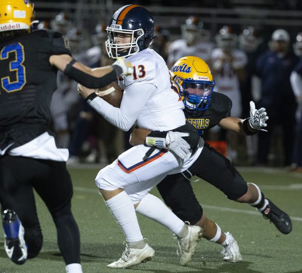 Warren's Royce Lopez, right, sacks Oswego's Brogan Mello during a first-round game in the Class 8A playoffs in Gurnee on Friday, Oct. 27, 2023. (John Konstantaras / News-Sun)