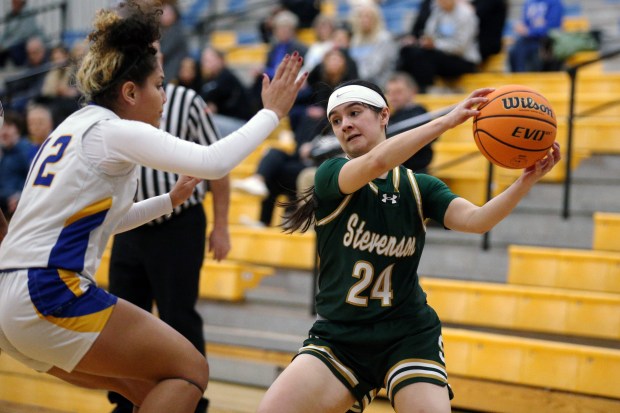 Stevenson's Megs Seribo (24), saving a ball from going out of bounds as Warren's Jelly Amezquita (left), pressures her, during the game on Friday, Jan. 10, 2024, in Gurnee. (Mark Ukena/for the Lake County News-Sun)