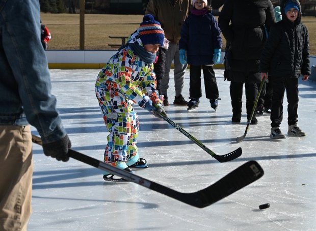 In colorful snowsuit gear, trying Shoot the Puck is Daniel Knizhnik, 7, a second-grader from Mundelein at the third annual Skate in the Park in Grayslake on Jan. 18, 2025. (Karie Angell Luc/Lake County News-Sun)