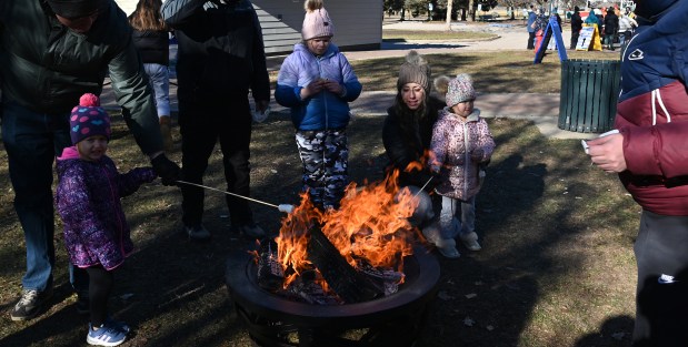 Making s'mores on right, kneeling, is parent Jazmin Halvorsen of Kenosha, Wisconsin. With her mother is Leighton Halvorsen, 3, at Frosty Fest on Jan. 4, 2025 at Viking Park (4374 Old Grand Ave.) in Gurnee. (Karie Angell Luc/Lake County News-Sun)