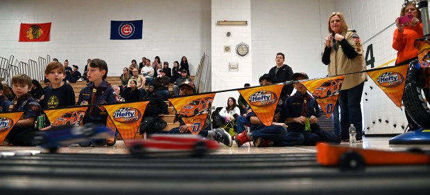 Top second from right, is Beth Johnson of Gurnee, showing excitement as cars pass the finish line at the Cub Scout Pack 627 of Gurnee Pinewood Derby on Jan. 26, 2025 in the gym at Woodland Elementary School in Gages Lake. (Karie Angell Luc/Lake County News-Sun)