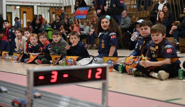 Top center, Charlotte Martinez, 8, a third-grader from Lindenhurst, shows excitement as her blue Sonic the Hedgehog car is about to cross the finish line at the Cub Scout Pack 627 of Gurnee Pinewood Derby on Jan. 26, 2025 in the gym at Woodland Elementary School in Gages Lake. (Karie Angell Luc/Lake County News-Sun)