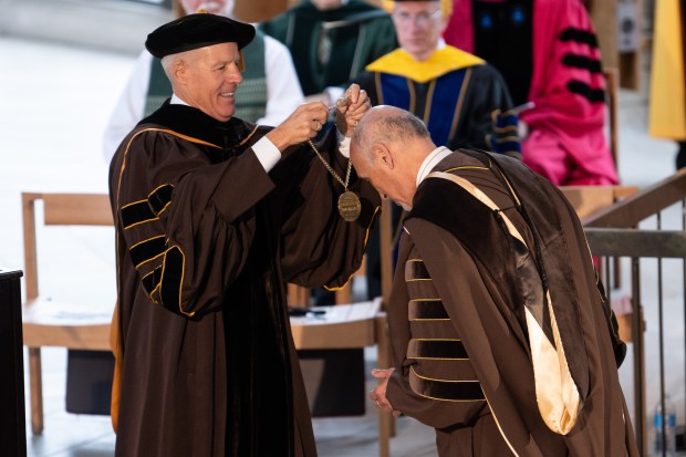 Former Valparaiso University President Mark Heckler passes a medal to newly inaugurated President Jose Padilla on Saturday, October 30, 2021. (Kyle Telechan for the Post-Tribune)