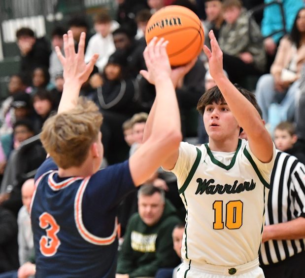 Waubonsie Valley's Josh Tinney (10) shoots for three points over Naperville North's Carson Loughlin (3) during a game on Tuesday, Jan. 7, 2025 in Aurora...(Jon Cunningham/for The Naperville Sun)