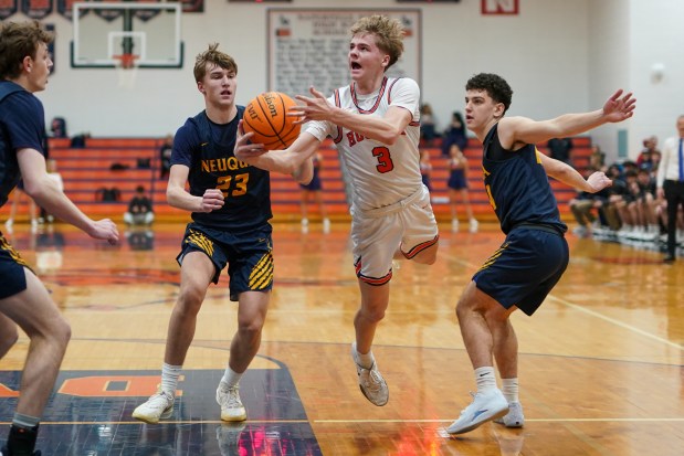 Naperville North's Carson Loughlin (3) shoots the ball in the post against Neuqua Valley's Cole Kelly (23) during a DuPage Valley Conference basketball game at Naperville North High School on Friday, Jan. 13, 2017. (Sean King / for The Naperville-Sun)