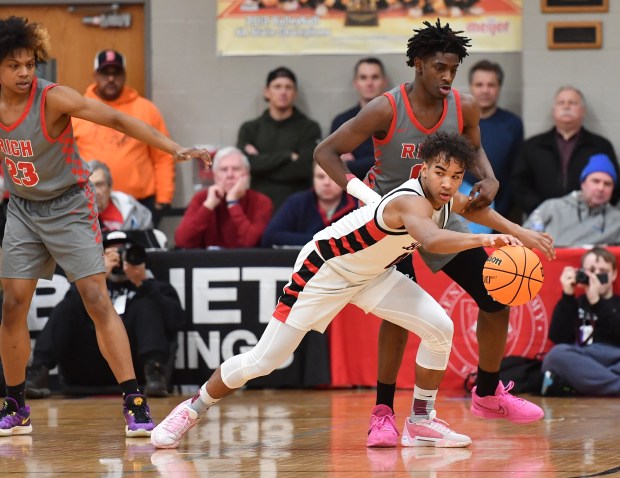 Benet's Blake Fagbemi looks for an open teammate even as he snags a loose ball during a When Sides Collide event game against Rich Township on Saturday, Jan. 25, 2025 in Lisle...(Jon Cunningham/for The Naperville Sun)