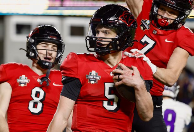 North Central College quarterback Luke Lehnen (5) celebrates with teammates Jack Rummell (8) and Thomas Skokna (7) after scoring a touchdown against Mount Union during the Stagg Bowl, the NCAA Division III national championship game, in Houston on Sunday, Jan. 5, 2025. NCC won 41-25. (Steve Woltmann / NCC)