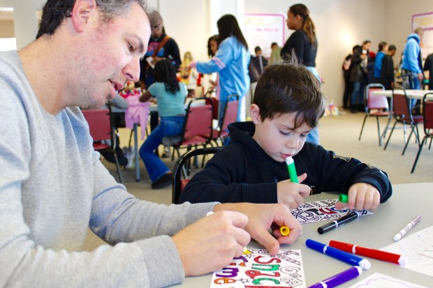 Jeff Glazer and Harry Glazer (6) of Highland Park work together during this year's Fill a Heart 4 Kids Martin Luther King experience on Monday, Jan. 20 The Gloria Dei Center, located in the Woodlands Academy of the Sacred Heart in Lake Forest, a day of service to benefit homeless children. (Gina Grillo/ for the Pioneer Press)