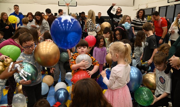 Center, in orange clothing, holding two balloons is Emmett Lapin, 4, of unincorporated Deerfield after the balloons dropped at Noon Year's Eve on Dec. 31, 2024 in Deerfield at Sachs Recreation Center. (Karie Angell Luc/Pioneer Press)