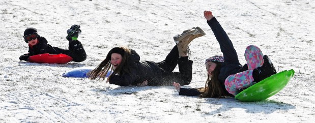 From second left to right, Mundelein friends Ophelia Orlick-Yesh and Abby Andersen, both 10, and fifth-graders, during a sledding moment at Winterfest in Vernon Hills at Century Park Arboretum on Jan. 11, 2025. (Karie Angell Luc/Pioneer Press)