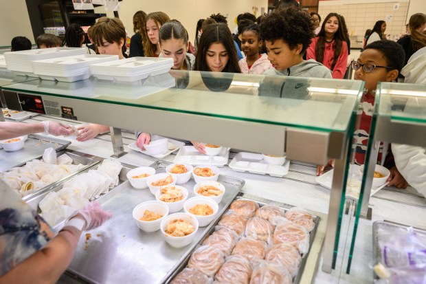 Fegley Middle School students line up to try a special arroz con pollo lunch, made from principal Ann Marie Caballero's grandmother's recipe, on Wednesday, Jan. 29, 2025. (Kyle Telechan/for the Post-Tribune)